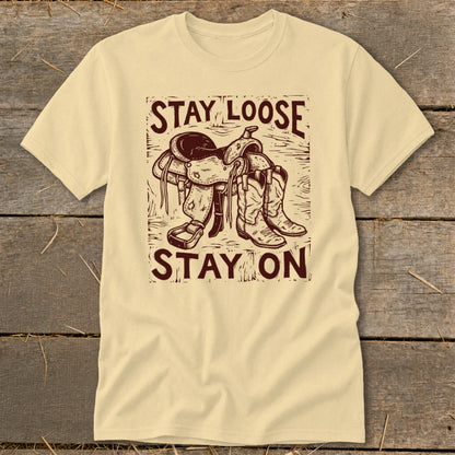 Light yellow t-shirt with "STAY LOOSE STAY ON" and saddle and boots graphic.