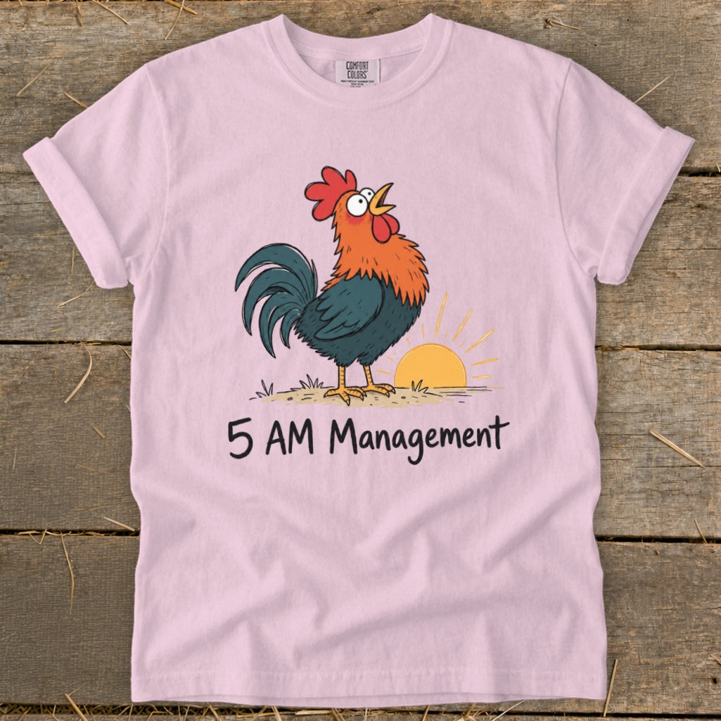 Pink t-shirt with cartoon rooster crowing at sunrise and text "5 AM Management."