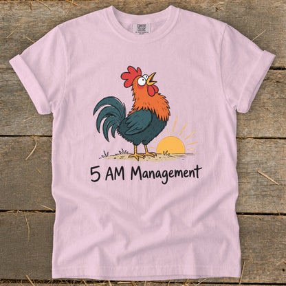 Pink t-shirt with cartoon rooster crowing at sunrise and text "5 AM Management."