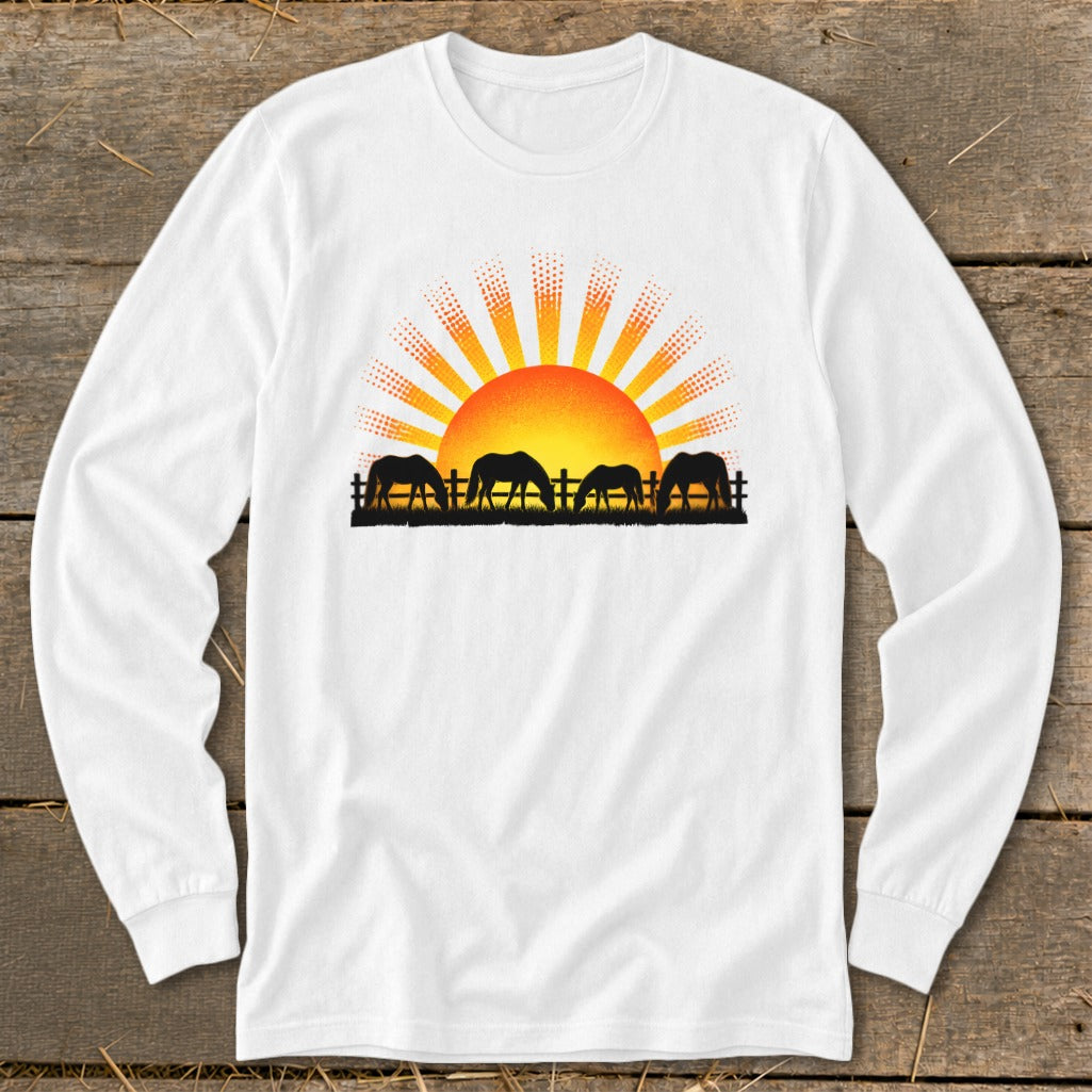 White long-sleeve shirt with horses grazing at sunrise graphic.