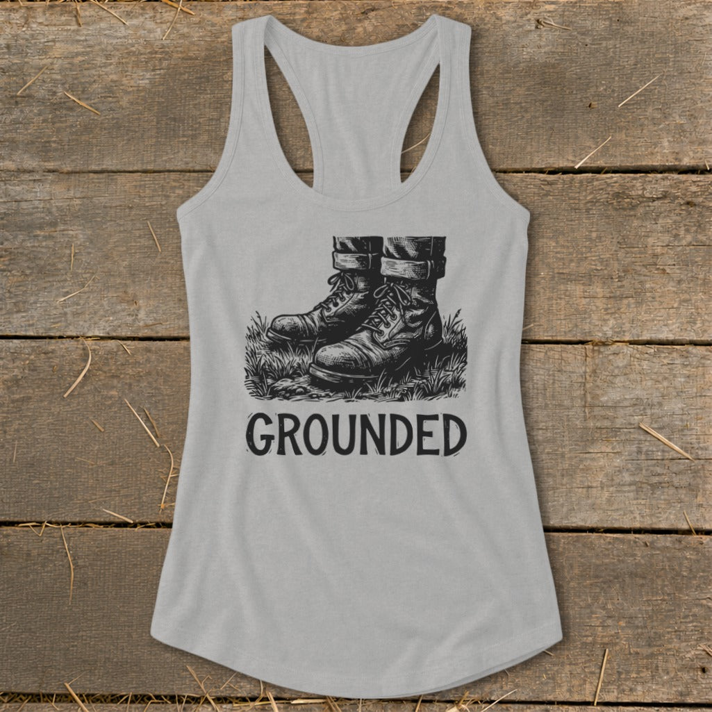 Gray tank top with black graphic of boots in grass and text "GROUNDED".