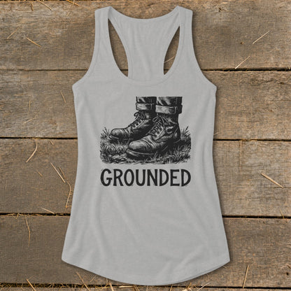 Gray tank top with black graphic of boots in grass and text "GROUNDED".