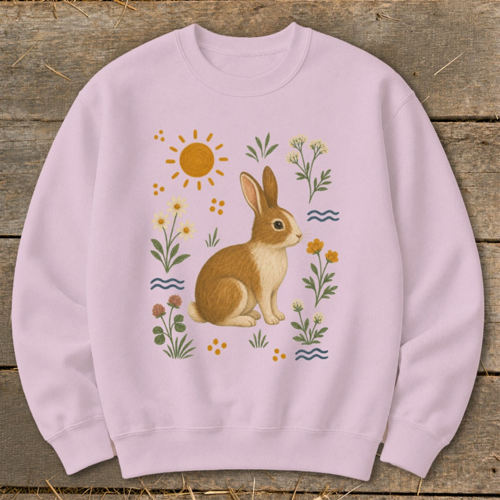 Pink sweatshirt with a whimsical rabbit and floral sun graphic.