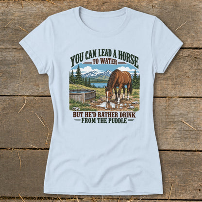 A light blue t-shirt printed with a graphic of a horse drinking from a puddle.
