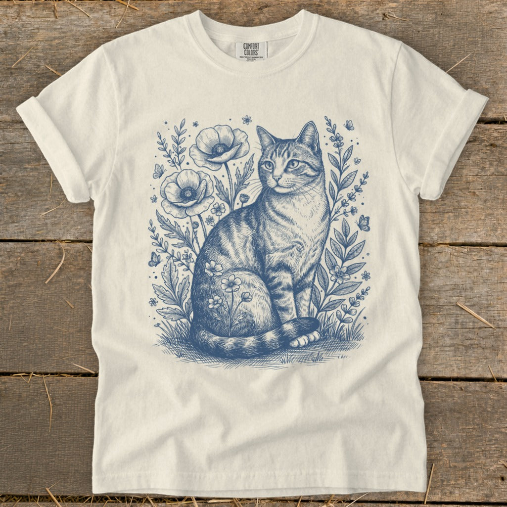 T-shirt with blue sketch of a tabby cat amongst flowers and butterflies.