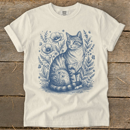 T-shirt with blue sketch of a tabby cat amongst flowers and butterflies.