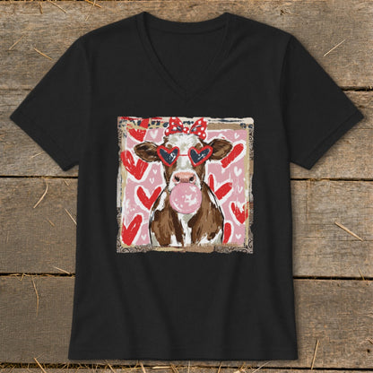 Cow wearing heart sunglasses and a bow, blowing bubblegum on a pink background with hearts.