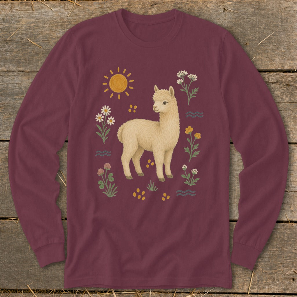 Cream alpaca with sun, flowers, and wavy lines on maroon long-sleeve shirt.