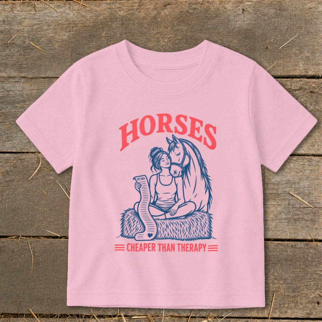 Pink t-shirt with graphic of woman and horse, "Horses Cheaper Than Therapy" text.