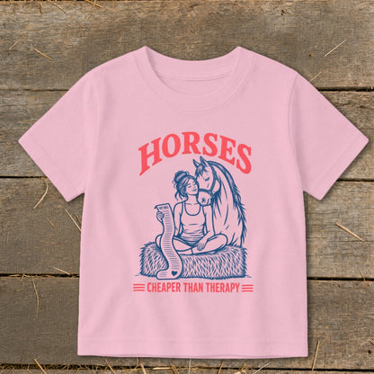 Pink t-shirt with graphic of woman and horse, "Horses Cheaper Than Therapy" text.