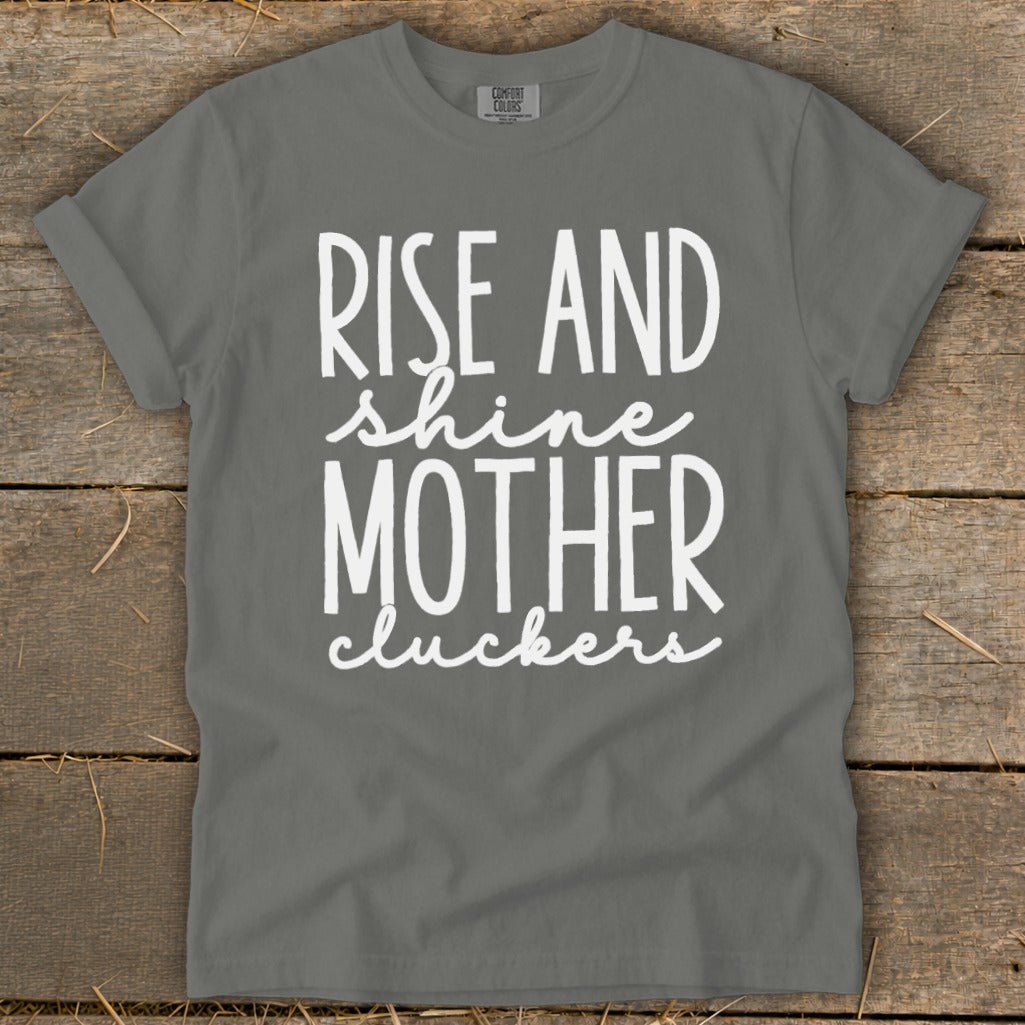 Grey t-shirt with white text: "Rise and shine Mother cluckers".