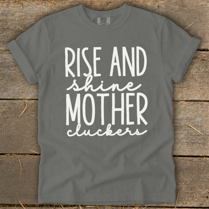 Grey t-shirt with white text: "Rise and shine Mother cluckers".