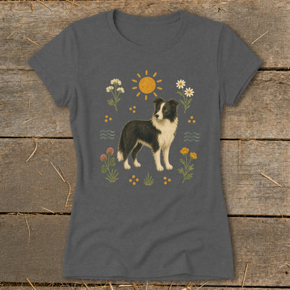 T-shirt with a watercolor illustration of a black and white Border Collie surrounded by flowers and a sun.