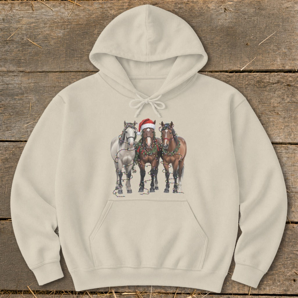 Three horses wearing Christmas lights and a Santa hat, printed on a cream hoodie.