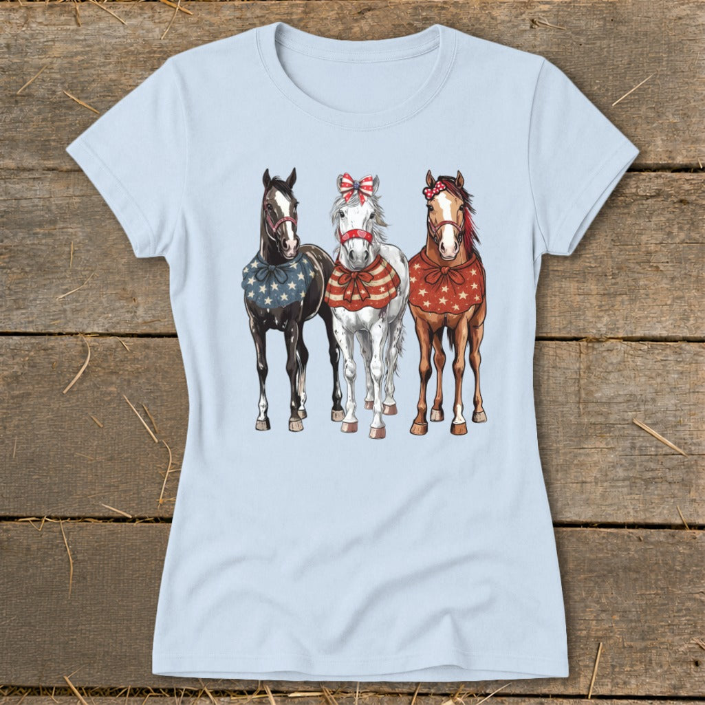 Three horses in festive patriotic attire stand together, with patriotic bows and star-patterned coverings.