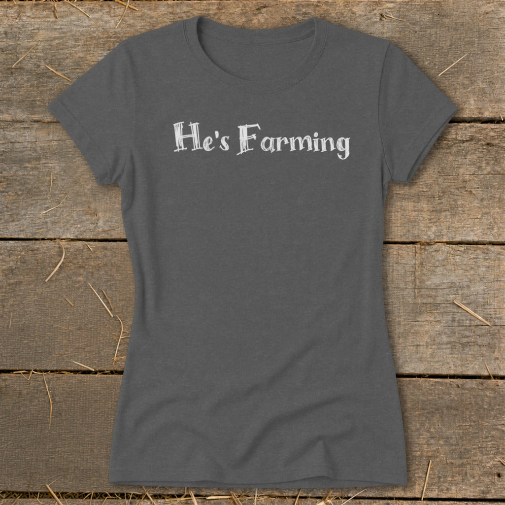 Dark grey t-shirt with "He's Farming" text in white distressed font.