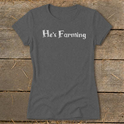 Dark grey t-shirt with "He's Farming" text in white distressed font.