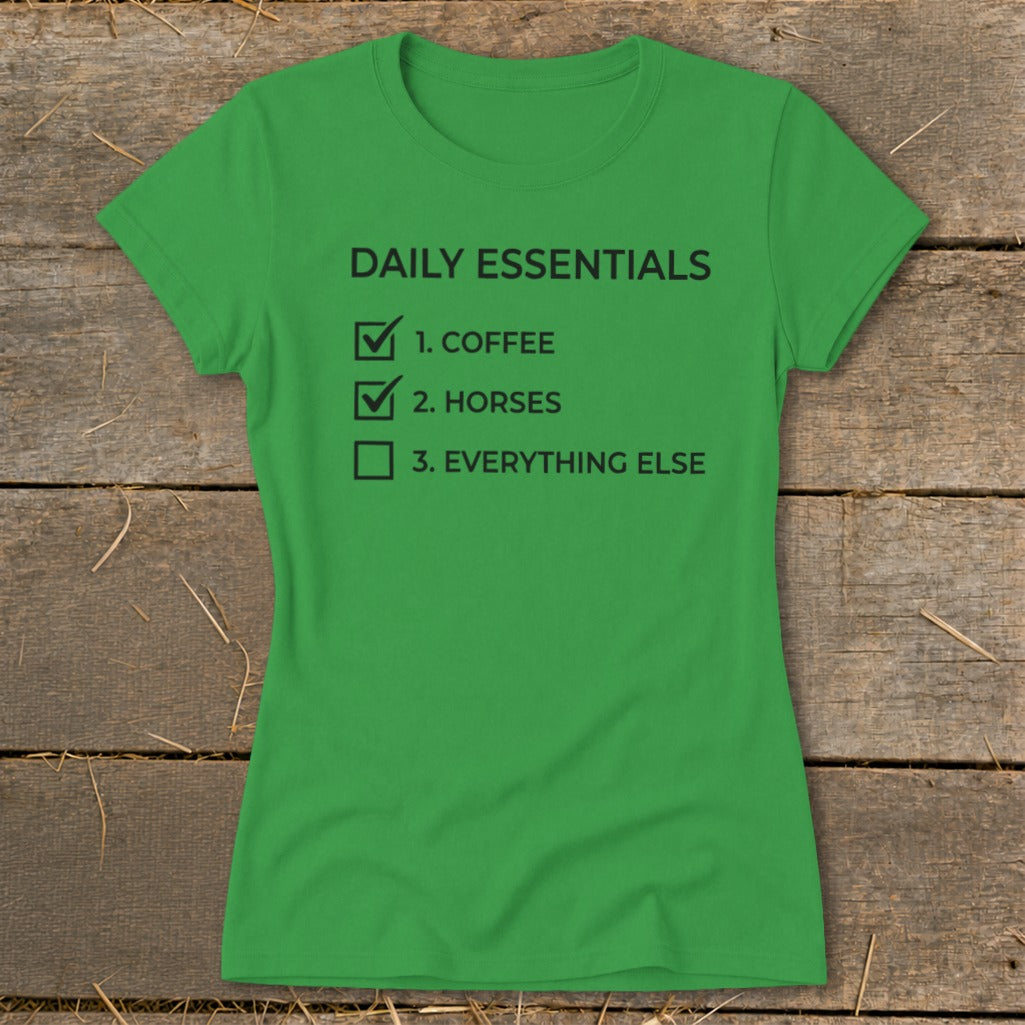 Green t-shirt with black text: "Daily Essentials. 1. Coffee. 2. Horses. 3. Everything Else."