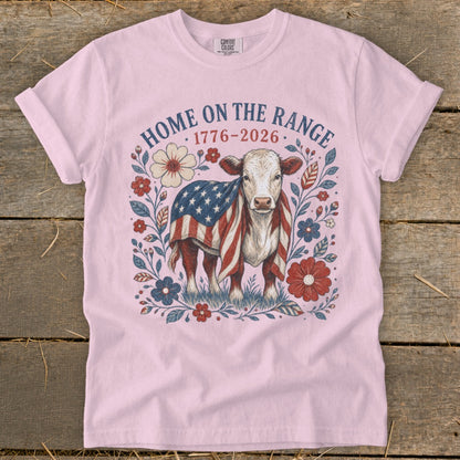 Cow with American flag draped on its back, surrounded by flowers. "HOME ON THE RANGE 1776-2026" text.