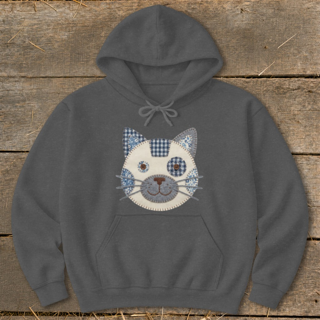 Dark gray hoodie with a patchwork cat face applique and buttons for eyes.