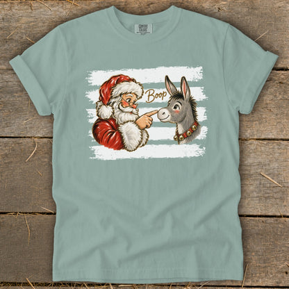 Santa touching a donkey's nose with the word "Boop" on a shirt.