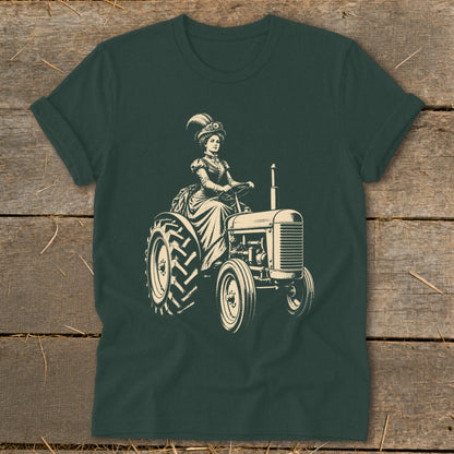 Woman in vintage dress driving a tractor, cream graphic on dark green t-shirt.