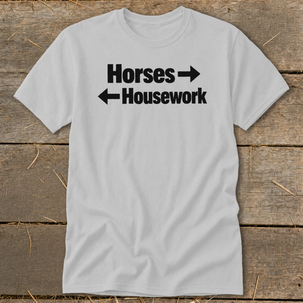 A light grey t-shirt featuring black text reading Horses pointing right and Housework pointing left.