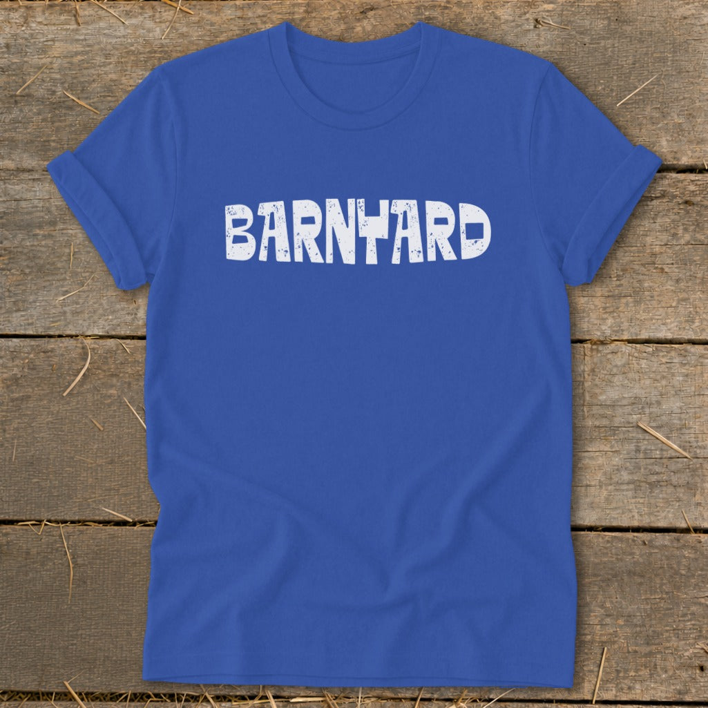 Royal blue crewneck t-shirt with rolled sleeves featuring distressed white text spelling BARNYARD on a wooden surface.