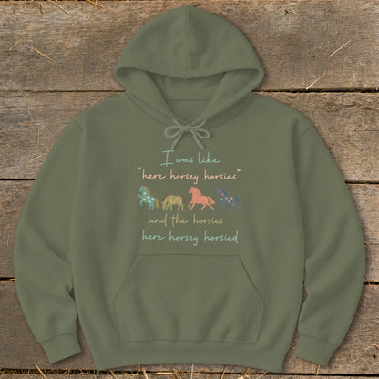 Olive green hoodie with text and four cartoon horses.