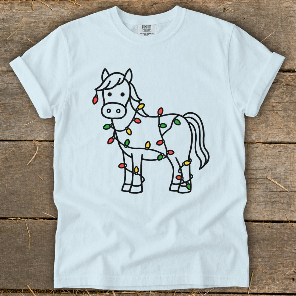 White t-shirt with line art of a horse wrapped in colorful Christmas lights.