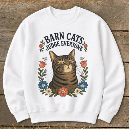 White sweatshirt with "Barn Cats Judge Everyone" text and a judgmental tabby cat surrounded by flowers.