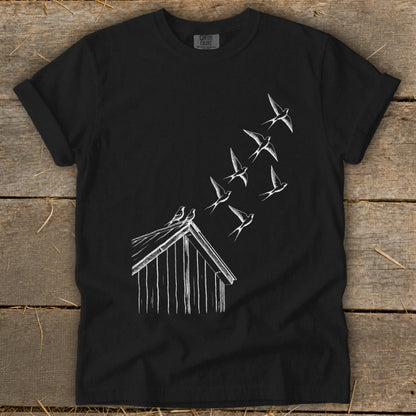 Black crewneck t-shirt featuring a white line drawing of a barn with birds flying upward.