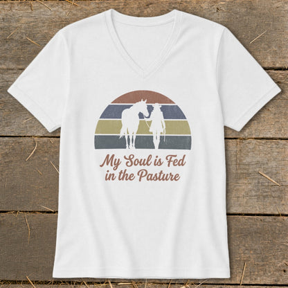 White v-neck t-shirt with horse and rider graphic and text.