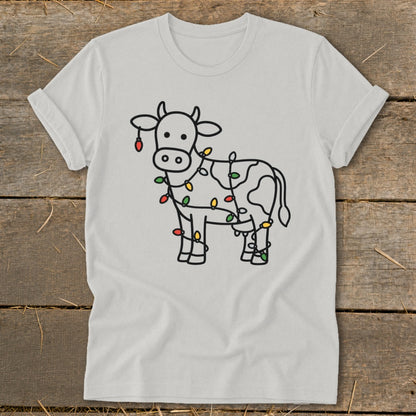 Light grey t-shirt with a line drawing of a cow wrapped in colorful Christmas lights.