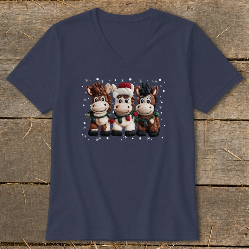 Three cartoon horses wearing scarves and one with a Santa hat, with snowflakes.