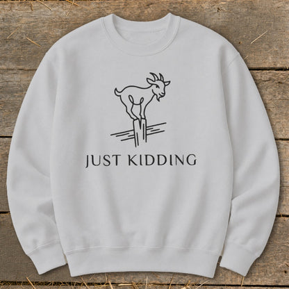 Light grey sweatshirt with a black line drawing of a goat on a fence post and text reading "JUST KIDDING".