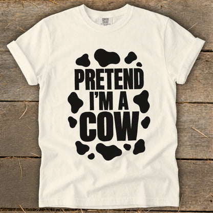 White t-shirt with black cow spots and the text "PRETEND I'M A COW".