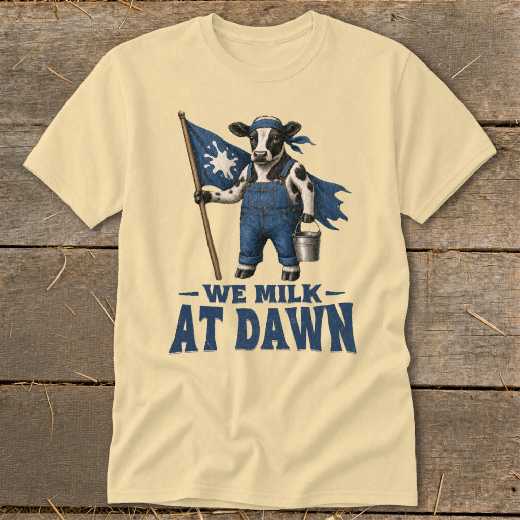 T-shirt with cow in overalls holding flag and milk bucket, reading "We Milk At Dawn".