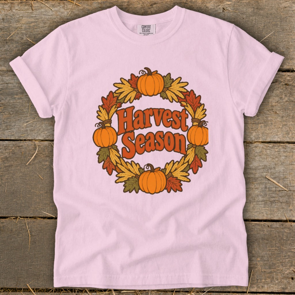 Pink t-shirt with "Harvest Season" text inside a pumpkin and leaf wreath.