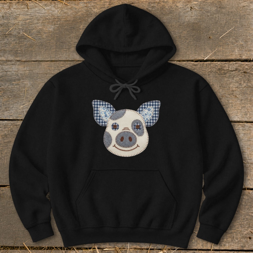 Black hoodie with a patchwork pig face applique on the chest.