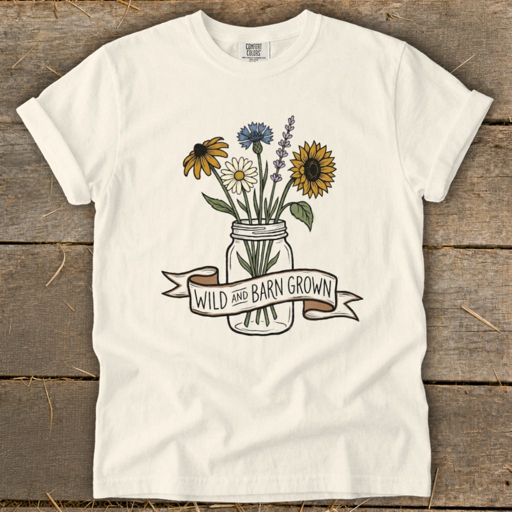 Cream t-shirt with a mason jar of wildflowers and a banner reading "WILD AND BARN GROWN."