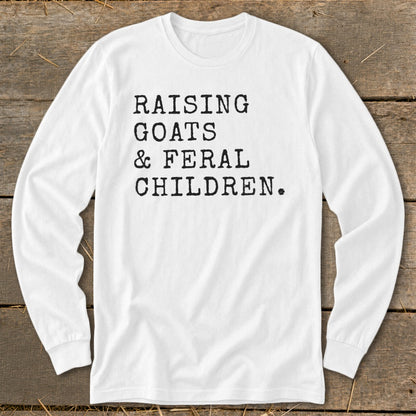 White long-sleeve shirt with black text: Raising Goats & Feral Children.