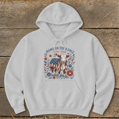 White hoodie with a graphic of a cow wrapped in an American flag, surrounded by flowers and text.