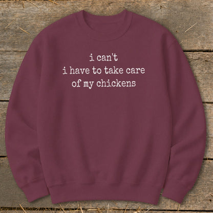 Maroon sweatshirt with white text "i can't i have to take care of my chickens".