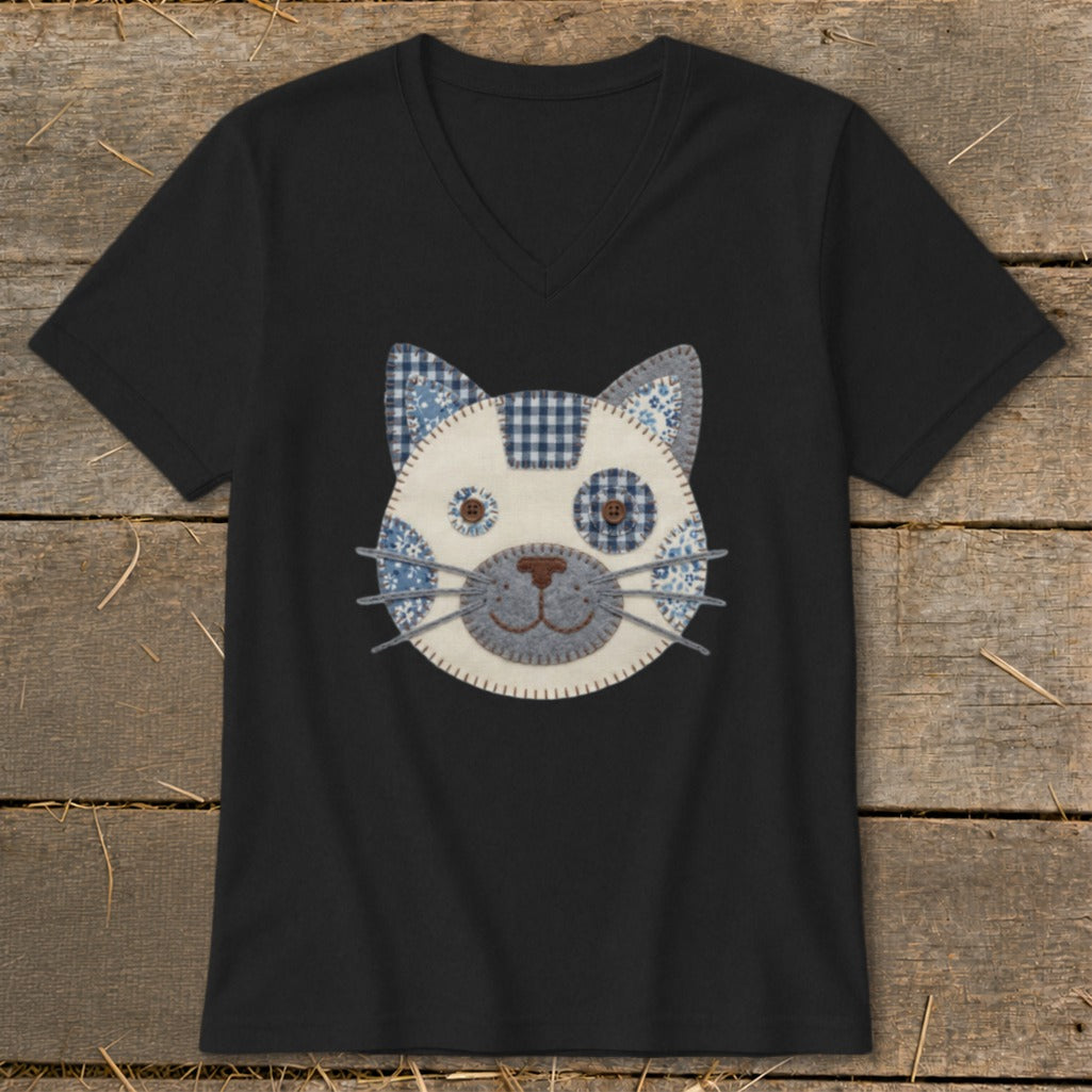 Black v-neck t-shirt with a patchwork cat face applique and button eyes.