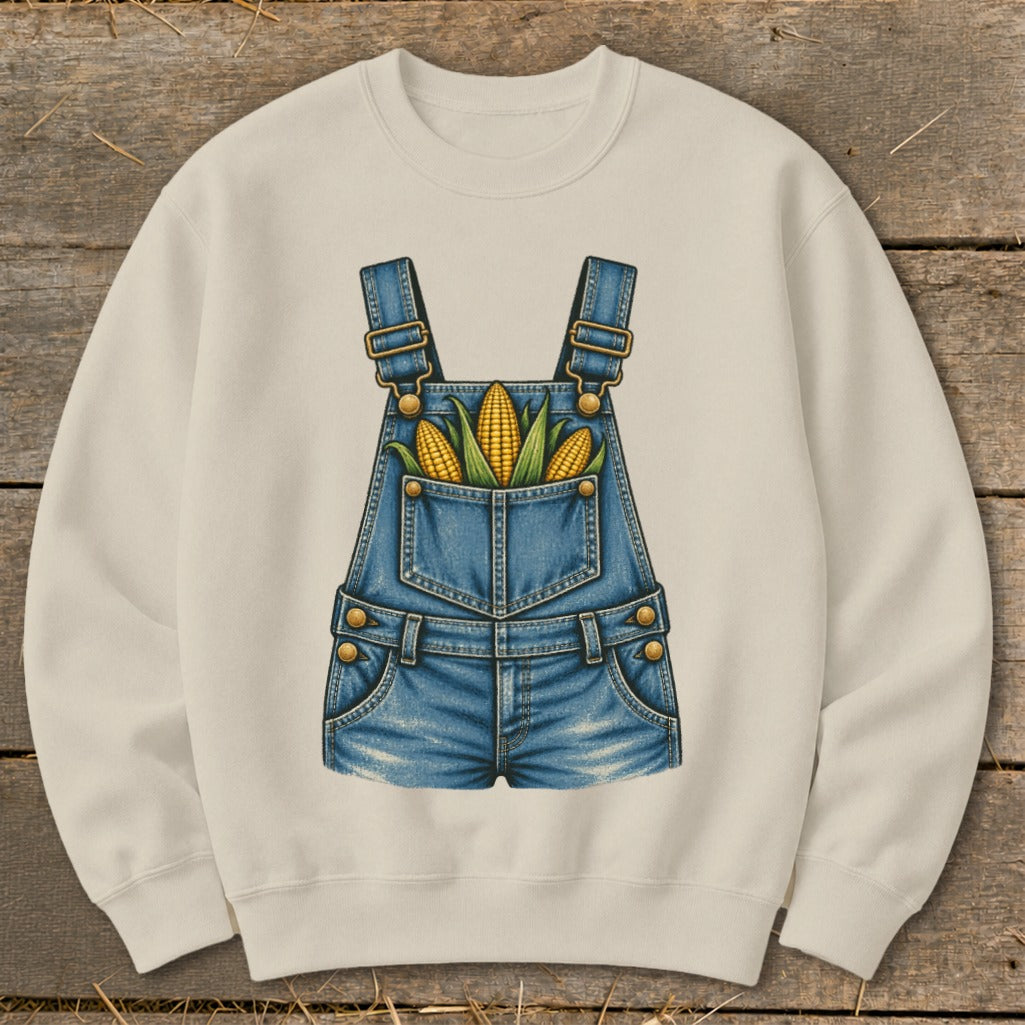Cream sweatshirt with denim overalls graphic featuring corn in the pockets.