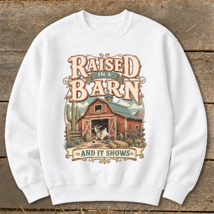 White sweatshirt with "Raised In A Barn And It Shows" text and a barn scene.