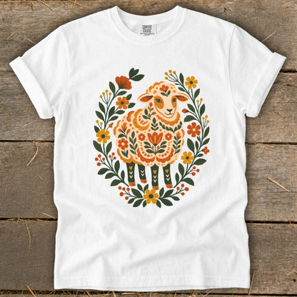 White t-shirt with a sheep design surrounded by floral elements.