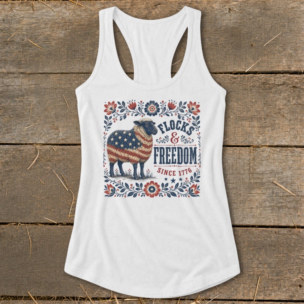White tank top with a sheep covered in the American flag and "Flocks & Freedom Since 1776" text.