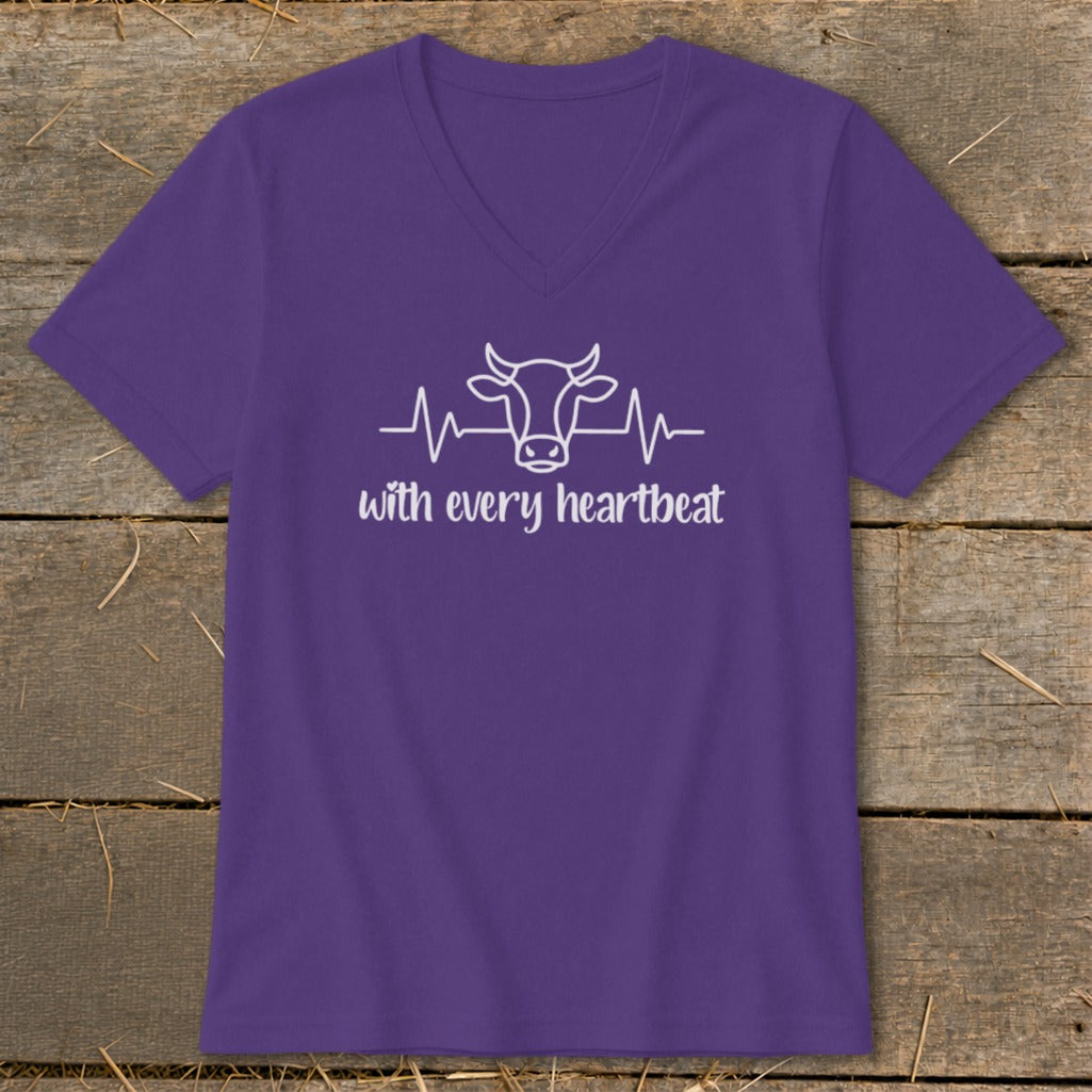Purple v-neck t-shirt with white outline of a cow head and heartbeat line, text "with every heartbeat".